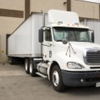 Transport truck backing up to a loading dock